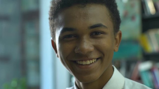 Afro-american student smiling sincere sitting in classroom, successful schooling