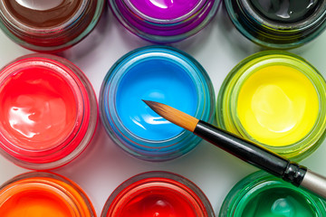 Multicolored bottles poster color and paintbrush on a white background Isolated Paints in...