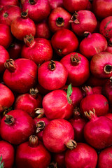 Background pattern of red ripe pomegranates in dark colors