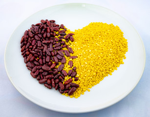 Red beans and golden beans in ceramic dish on white background