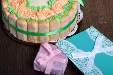 Sponge cake with cream cheese, decorated with Savoiardi cookies. On the side, wrapped in a ribbon...