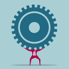 Businessman carrying huge gears. Isolated on blue background.