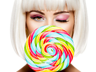 Face of a beautiful   girl with pink eye make-up and sweet candy.
