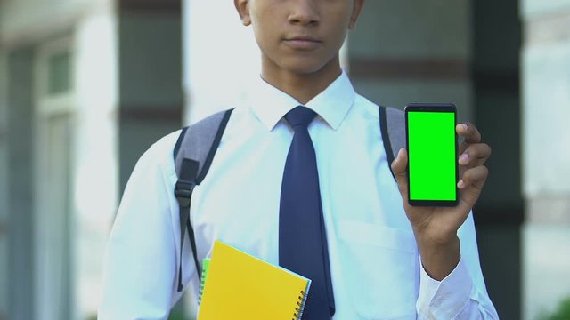 Serious student showing cell phone, apps for enrollment in specialized school
