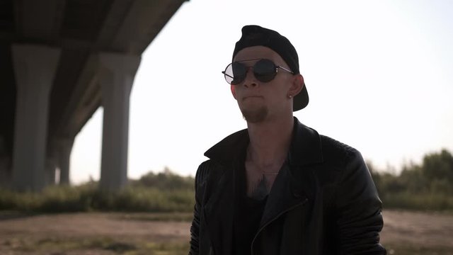 Close Up Caucasian Young Man Looking At Camera. Handsome Stylish Man. Portrait Of A Tough Guy In A Black Leather Jacket. Contemporary Dance. Krump. Hip Hop Style, Listening To Music. Closeup