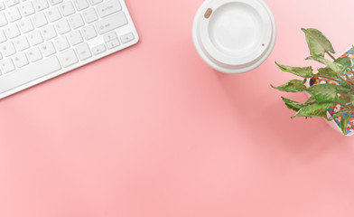 Top view with copy space of Computer keyboard and coffee mug overhead on pink pastel background, Flat lay concept