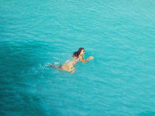 woman swimming freely at turquoise water of cambugahay waterfalls in Siquijor Island in Philippines