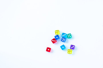 Rozrzucone kolorowe kostki do gry na białym tle