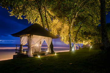 Romantic pavilion at evening time with dim light. A special place at beachfront with sunset for marriage proposal.