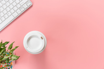 Top view with copy space of Computer keyboard and coffee mug overhead on pink pastel background, Flat lay concept