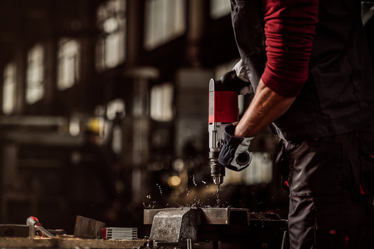 Man drilling in metal, hand drill