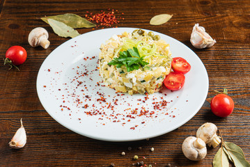 Russian salad on the wooden background