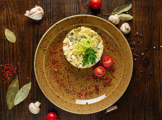 Russian salad on the wooden background