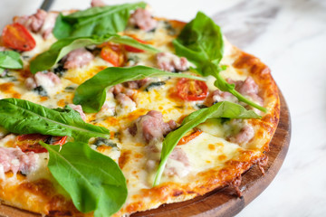 closeup rocket sausage pizza on marble table