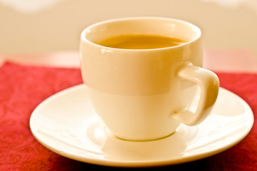 white cup with espresso coffee with beautiful foam on table 