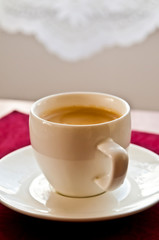 white cup with espresso coffee with beautiful foam on table 