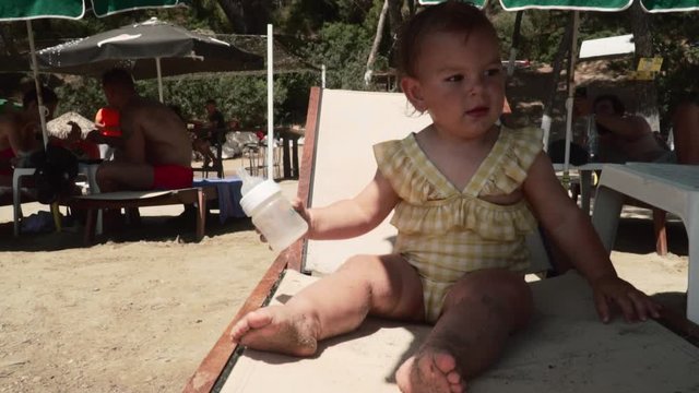 baby drinking water on the beach