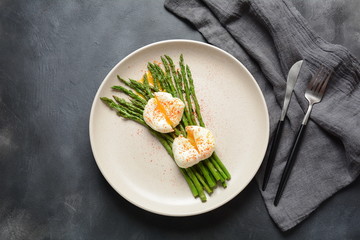 Green asparagus with poached eggs on a plate. Healthy breakfast concept
