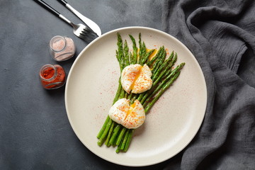 Green asparagus with poached eggs on a plate. Healthy breakfast concept