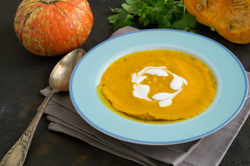 Vegetarian pumpkin cream soup on dark background.