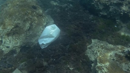  Plastic pollution, a lot of plastic trash bottom covered with algae. Top view. Plastic bottles, bags and dishes on the seabed in Mediterranean Sea, Europe. 