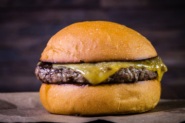 Craft beef burger with cheese on wood table and rustic background