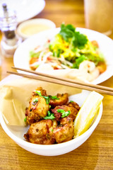 Pieces of deep-fried chicken in the Asian style are on the plate.