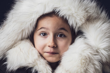 Close up portrait of a young girl dressed with an eskimo jacket  looking at the camera