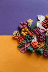 Multicolored pasta shapes on colorful background. 