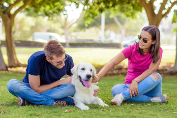 Couple lying in the park while having fun with the dog.happy family concept