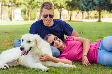 Couple lying in the park while having fun with the dog.happy family concept