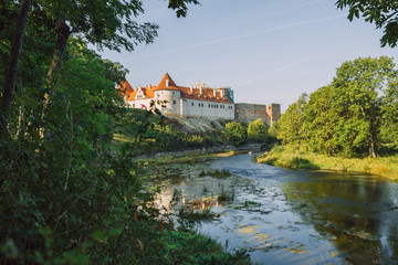 Fototapeta na wymiar City Bauska, Latvia Republic. Park with old castle and river. Trees and green zone. Sep 9. 2019 Travel photo.