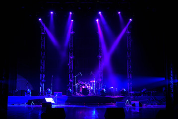 Lights beams on stage with musical instruments