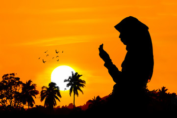 silhouettes of a women praying during sunset