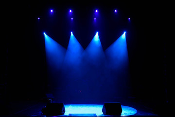 The light of searchlights in smoke on stage of the theatre.