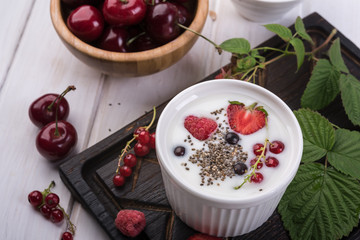 Healthy greek yogurt in a ceramic bowl with fresh berries and chia seeds