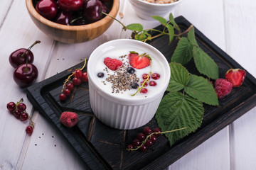 Healthy greek yogurt in a ceramic bowl with fresh berries and chia seeds