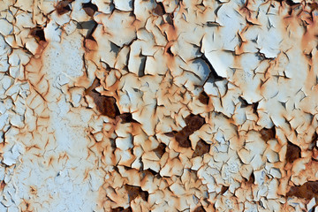 rusty metal wall with cracked blue paint, rust through the paint