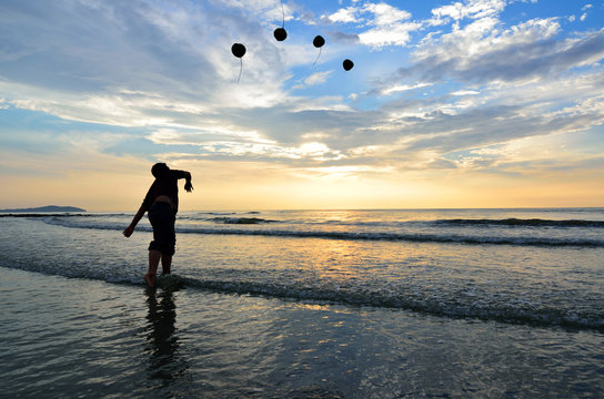 Man Throwing Coconut To The Beach