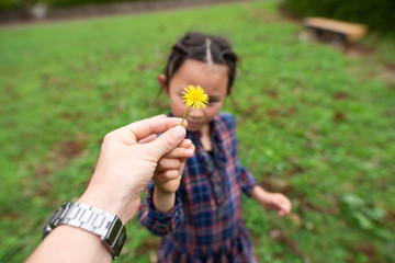 黄色い花を手渡す親子