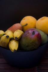 ripe fruits in a dark bowl
