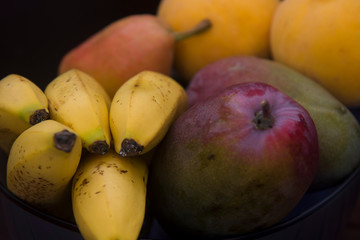 ripe fruits in a dark bowl