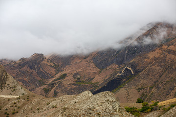 Picturesque landscape of mountain slope with green vegetation, cloudy gloomy sky