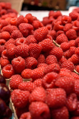 Fresh raspberries for sale in an indoor farmers market.  The market is Granville Market in Vancouver