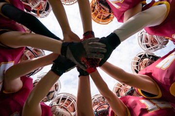 Image of female rugby players stacking their hands together - Powered by Adobe