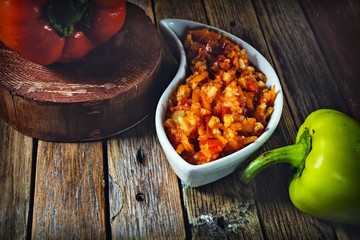 bell pepper with rice and tomato sauce on a wooden table