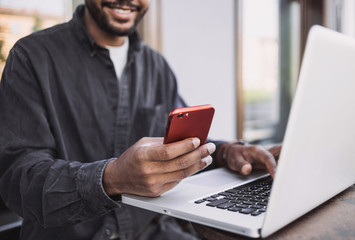 Handsome man using smartphone in a city. Young handsome student men having coffee break and texting...