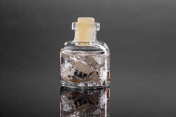 macro metal silver in a capsule on a gray background