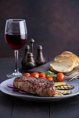 Grilled ribeye beef steak with red wine, vegetables and spices