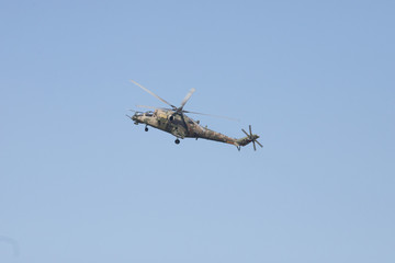 Fototapeta na wymiar A green military helicopter flying - clear blue sky